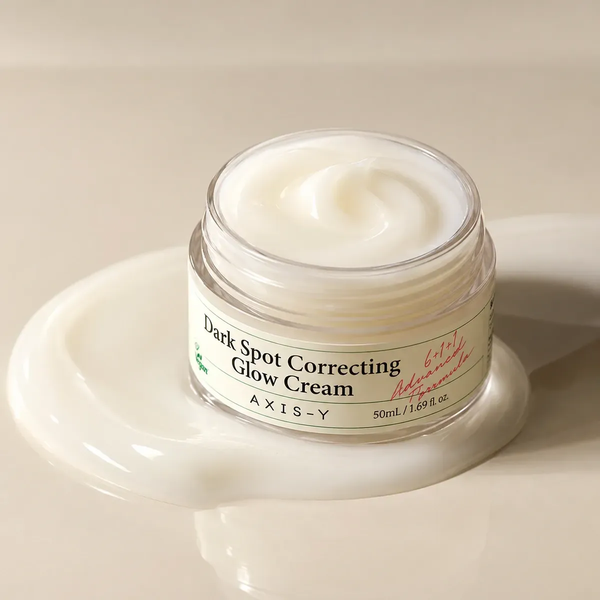 Axis-Y Dark Spot Correcting Glow Cream — баночка з кремом на кремовому тлі