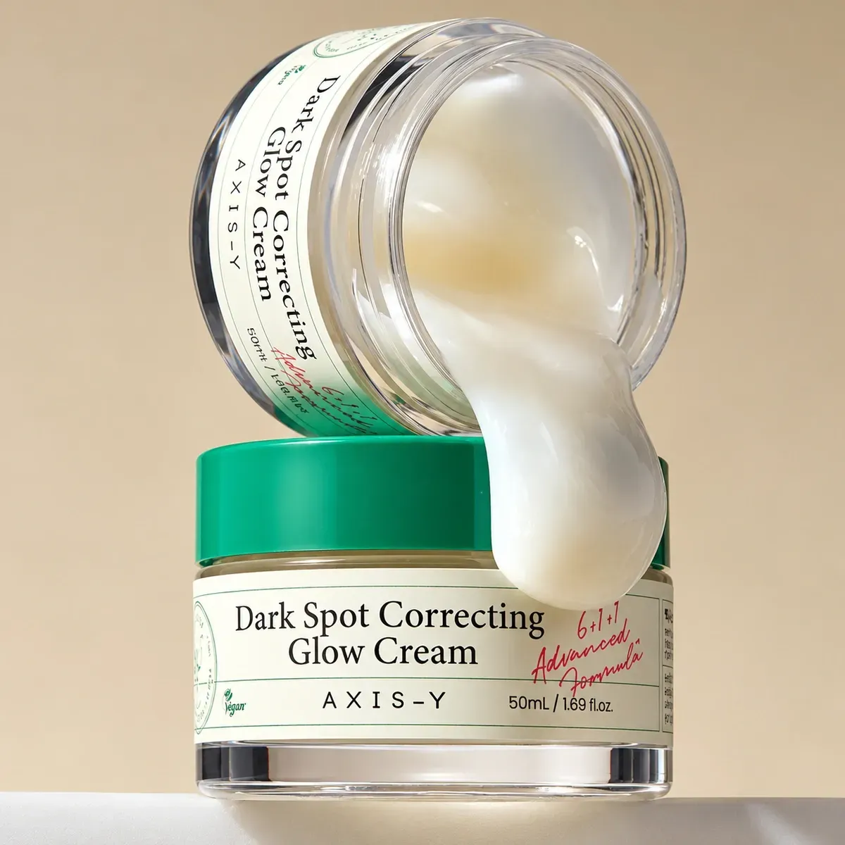 Axis-Y Dark Spot Correcting Glow Cream — відкрита баночка, з якої стікає білий крем
