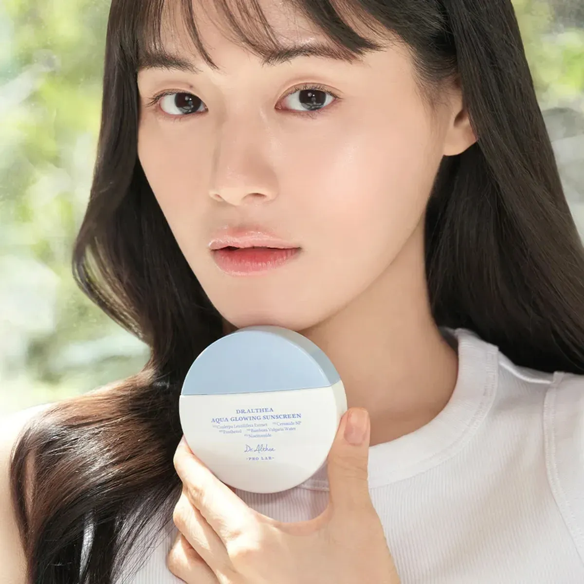 Dr.Althea Aqua Glowing Sunscreen — компактна баночка в руці